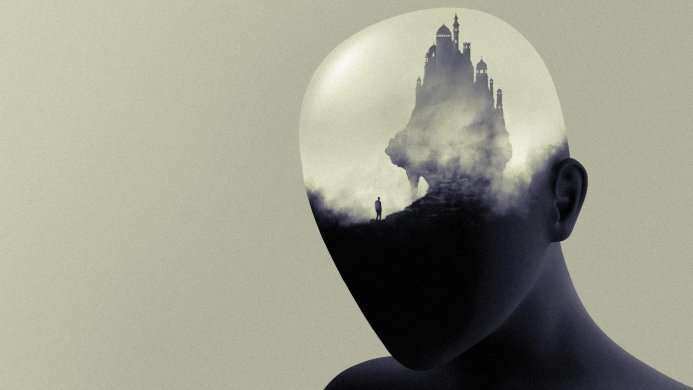 Castle inside head silhouette with small figure on mountain leading to castle