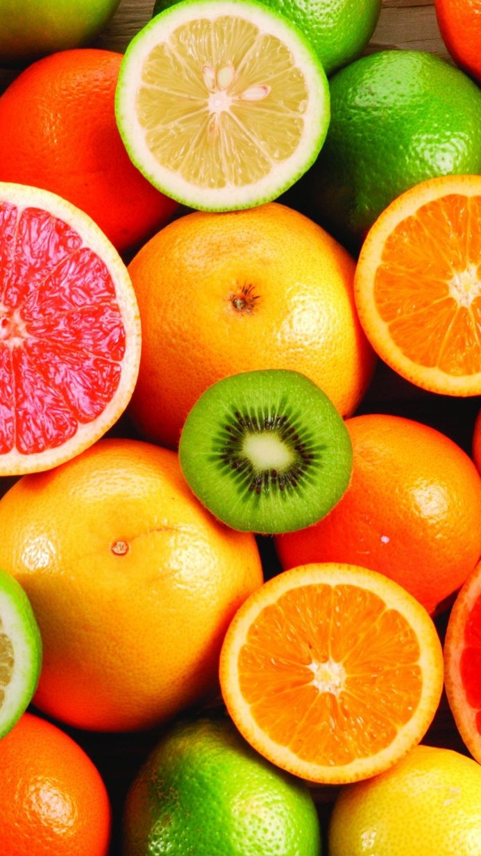 A vibrant assortment of citrus fruits including grapefruit, oranges, lemons, limes, and kiwi