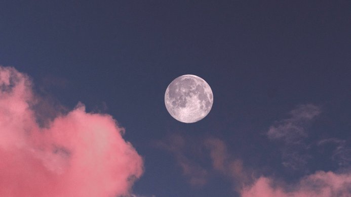 Full moon in a blue sky with pink clouds