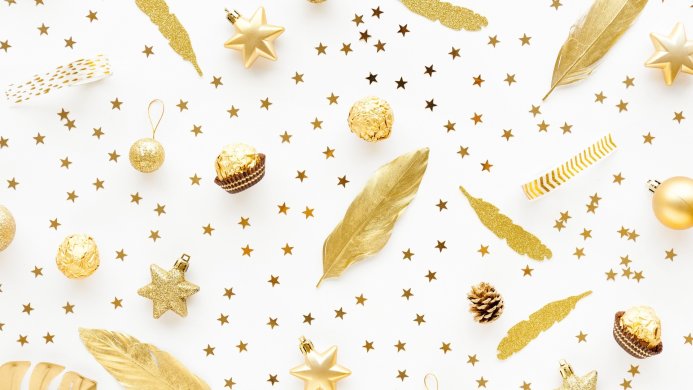 Gold Christmas ornaments, stars, and candies on a white background
