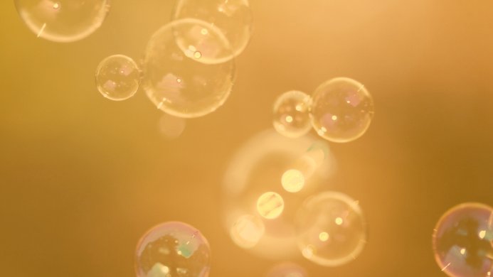 Floating soap bubbles against a golden background