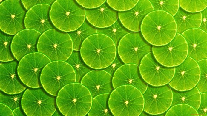 Close-up of many vibrant green lime slices forming a textured background