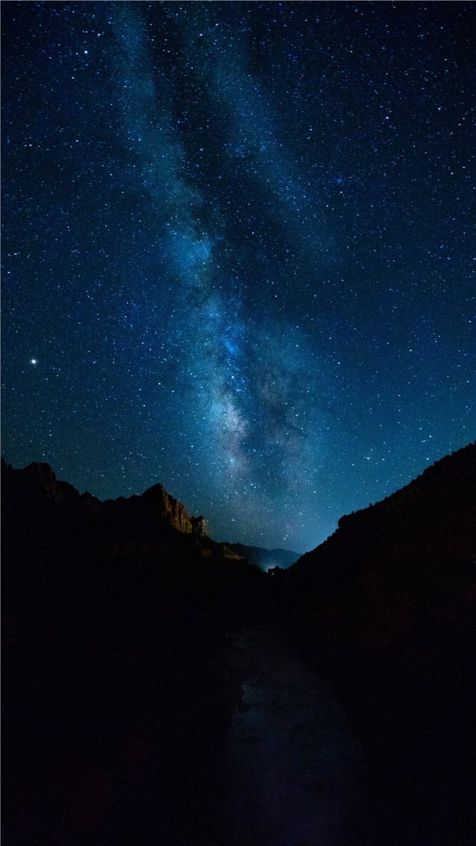 Milky Way stretching over dark mountains, a starry night sky