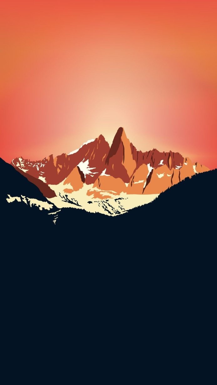 Mountain range with snow-capped peaks at sunrise with an orange sky