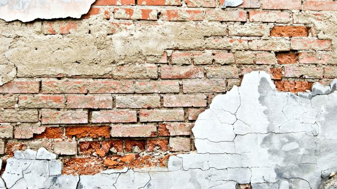Old brick wall with damaged plaster