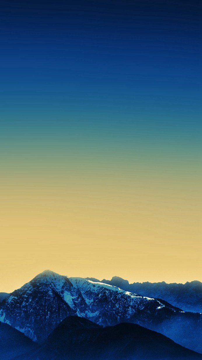 Mountain peak with snow, blue and yellow sky gradient