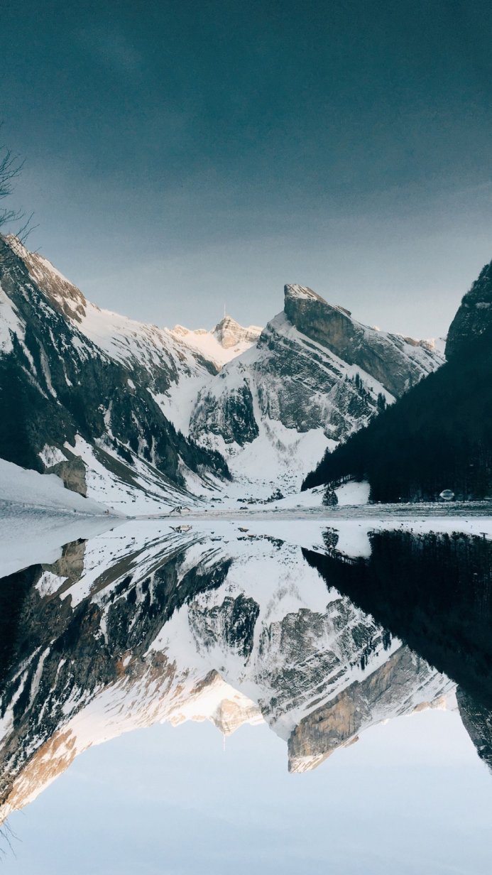 Snowy mountains reflected in a lake on a winter day