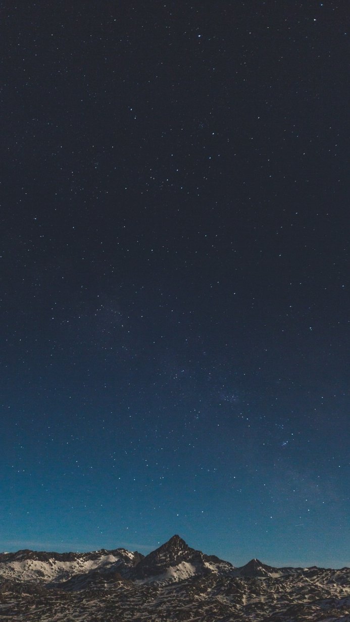 Snow-capped mountains under a starry night sky