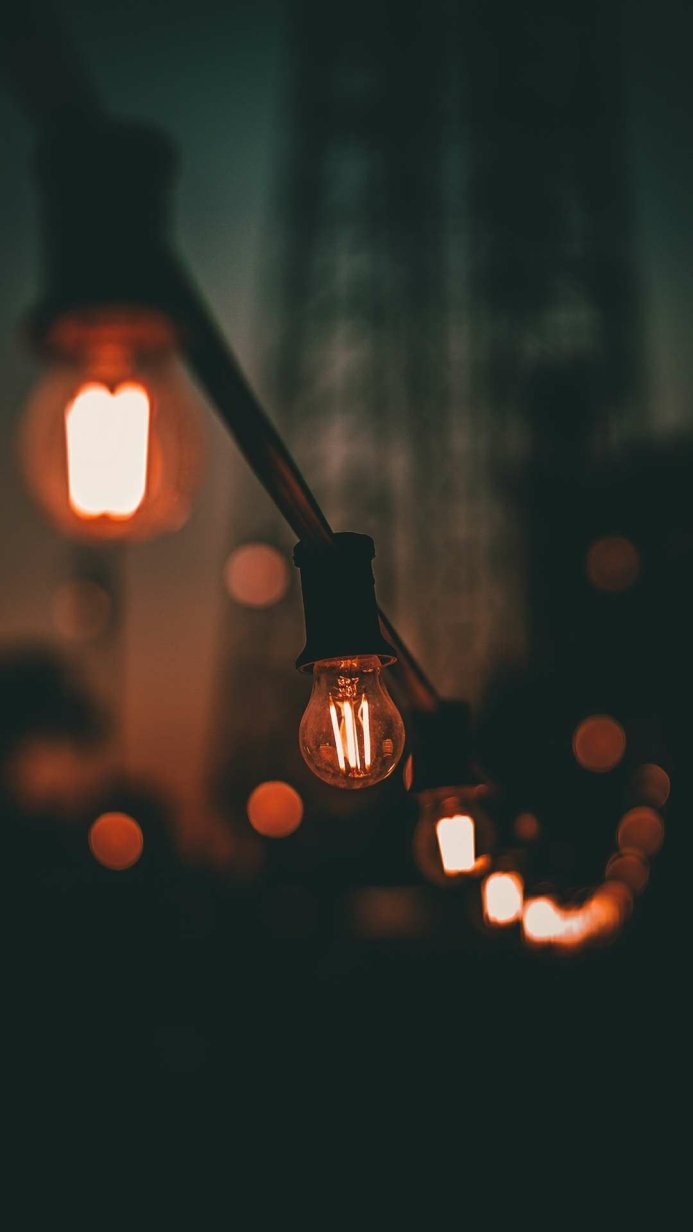 A string of orange light bulbs against a dark background