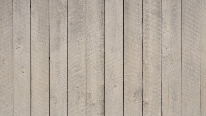 A weathered wooden plank wall with a beige and grey color palette