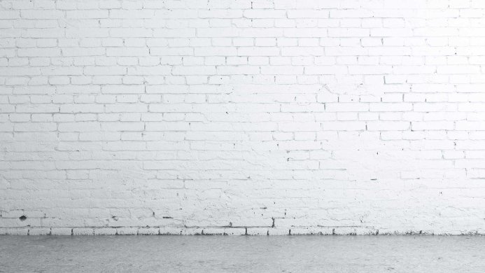 White painted brick wall texture with a grey concrete floor