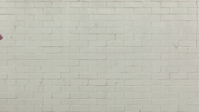 A white painted brick wall with a repeating pattern