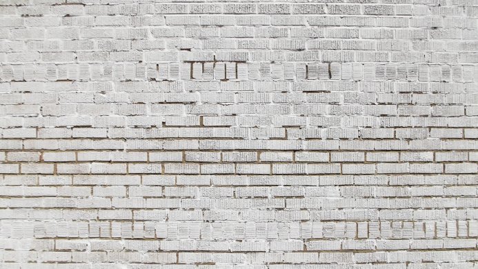 A textured white brick wall with visible mortar lines