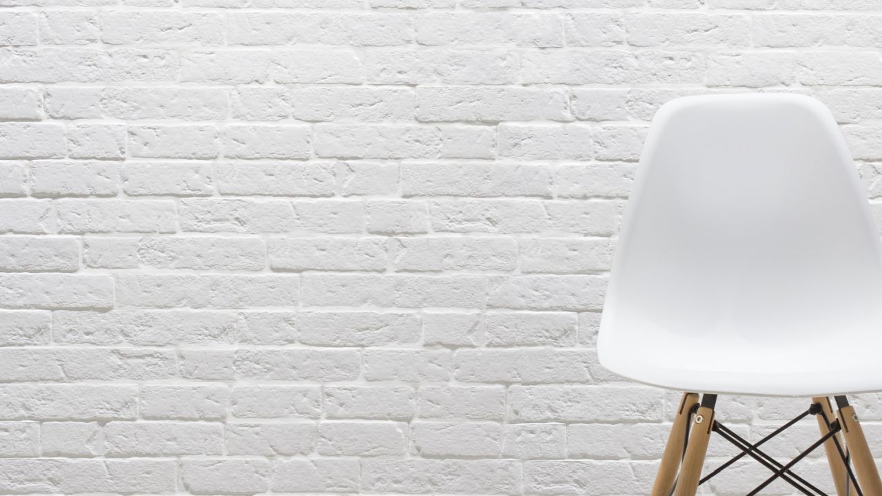 White chair against white brick wall