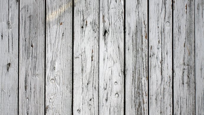 Aged white wooden planks with cracked paint, close up texture