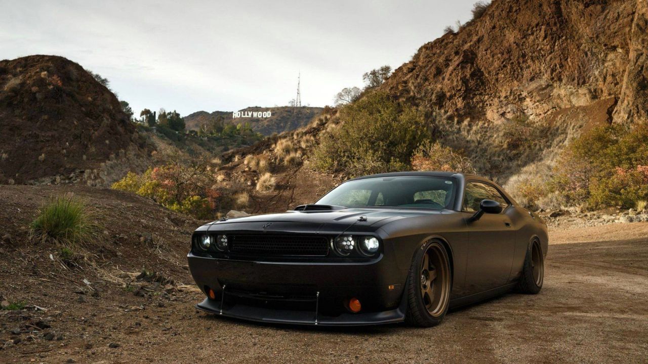 Black Dodge Challenger on a dirt road