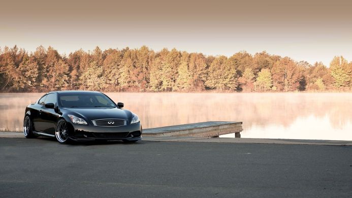 Black Infiniti G37 Coupe parked by a misty lake in the morning light