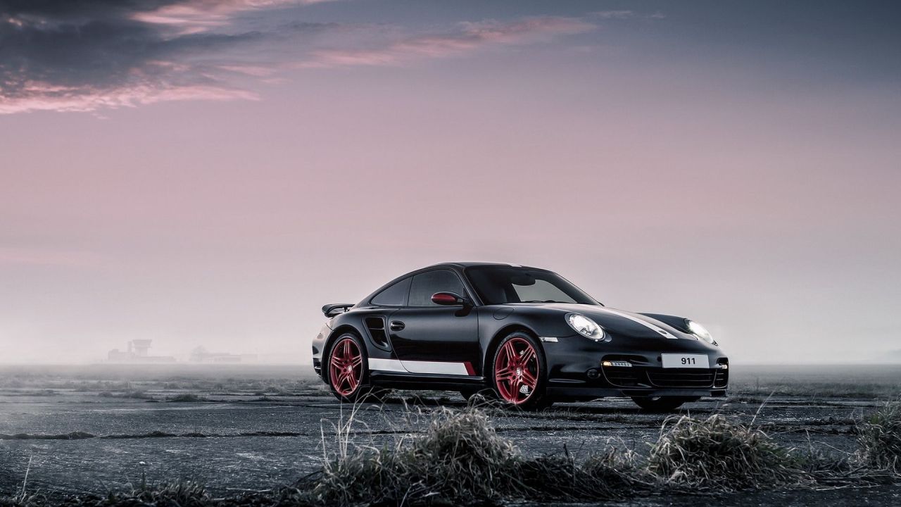 Black Porsche 911 with red wheels