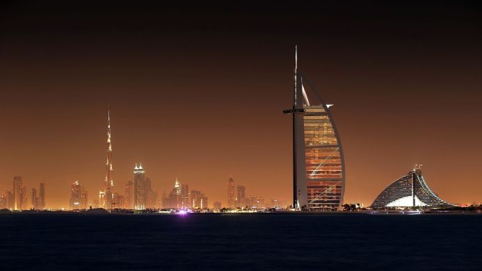 Dubai skyline featuring Burj Khalifa, Burj Al Arab, and Jumeirah Beach Hotel at night