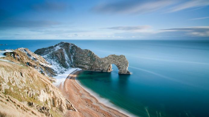 Durdle Door rock formation on the Dorset coast, with beach and blue sea