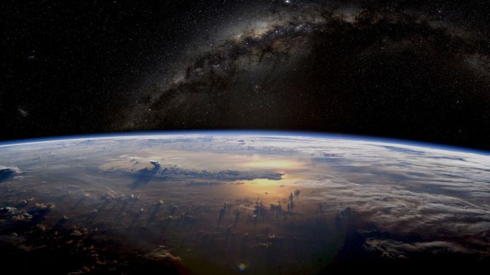 Earth from space with visible clouds, continents, and the Milky Way galaxy