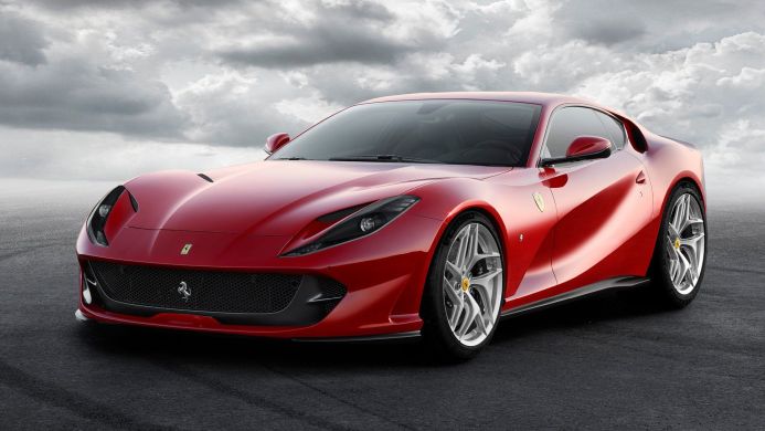Red Ferrari 812 Superfast parked on an asphalt road with a cloudy sky background