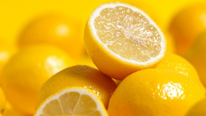 Close-up of fresh lemons on a yellow background
