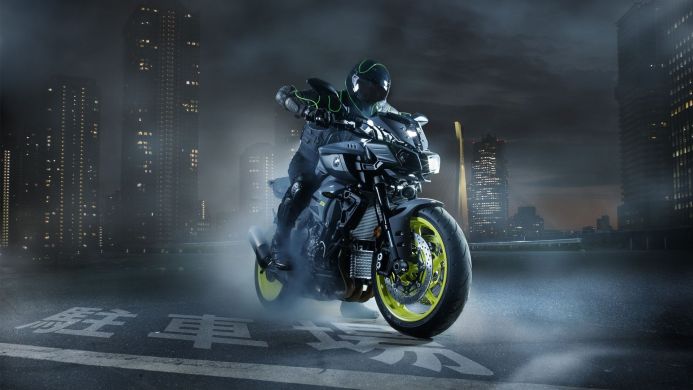 Motorcycle on a city street at night with skyscrapers in the background