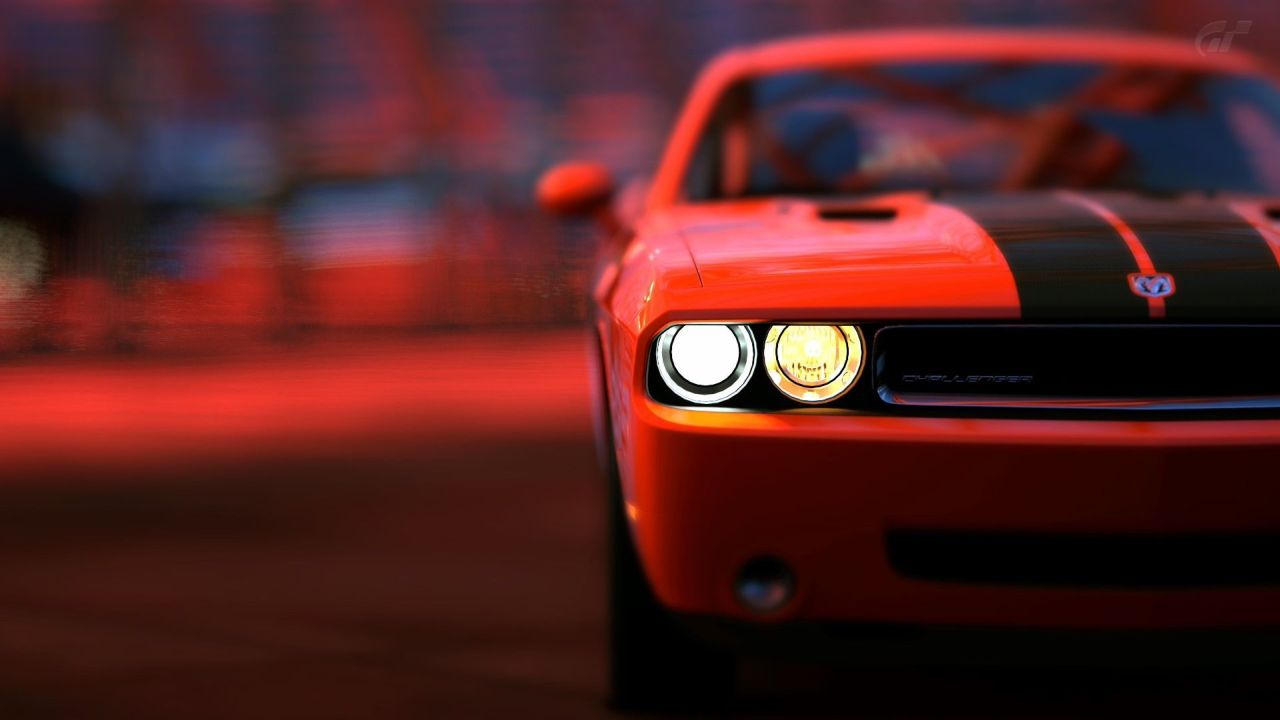 Orange Dodge Challenger with headlights on