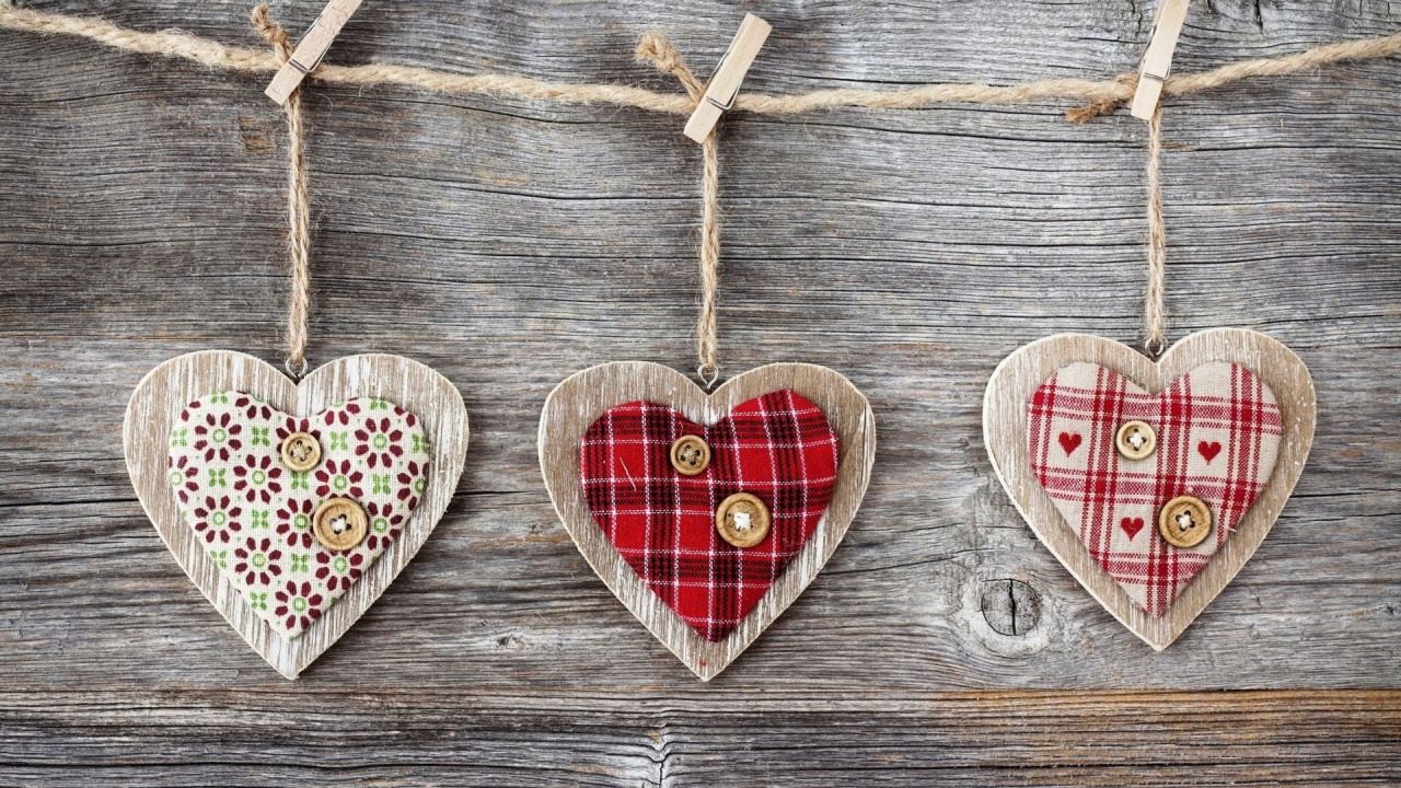 Three decorative hearts on wooden background