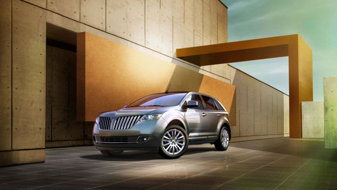 Silver Lincoln MKX parked in front of a modern concrete building with gold architectural features