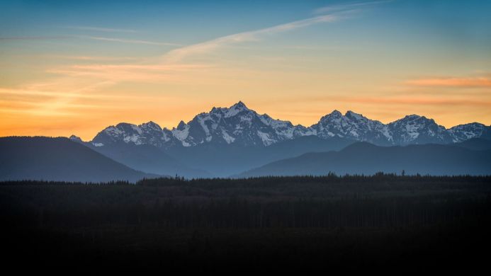 Snow-capped mountains against a colorful sunset sky