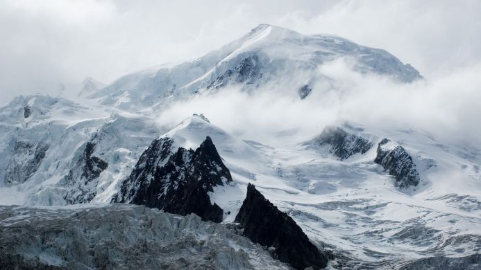 Snowy mountain peaks and glaciers under a cloudy sky