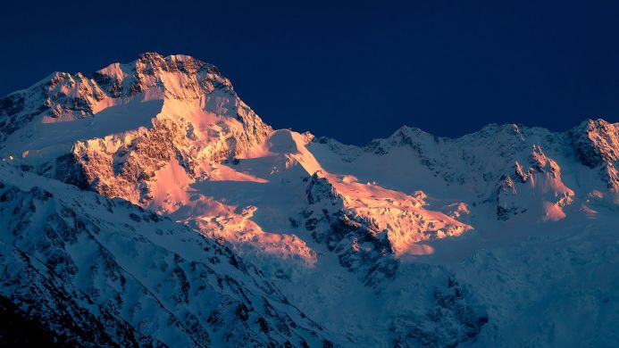 Snowy mountain range illuminated by the golden hour sunlight