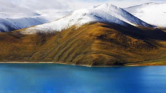 Snowy mountain peaks reflected in a turquoise lake, a beautiful mountain landscape