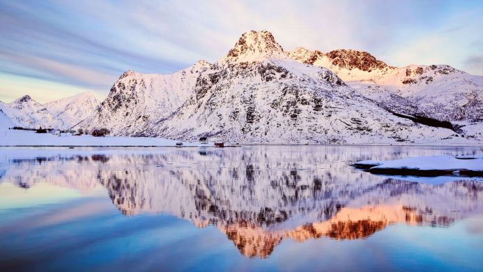 Snowy mountains reflecting in water, winter landscape scene