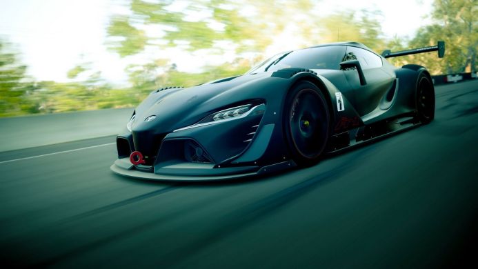 Dark gray Toyota racing car speeding on a track with blurred green background