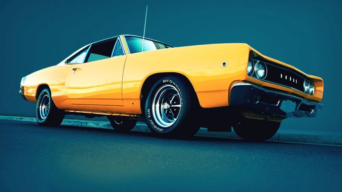Yellow 1968 Dodge Coronet classic muscle car parked on pavement, side view