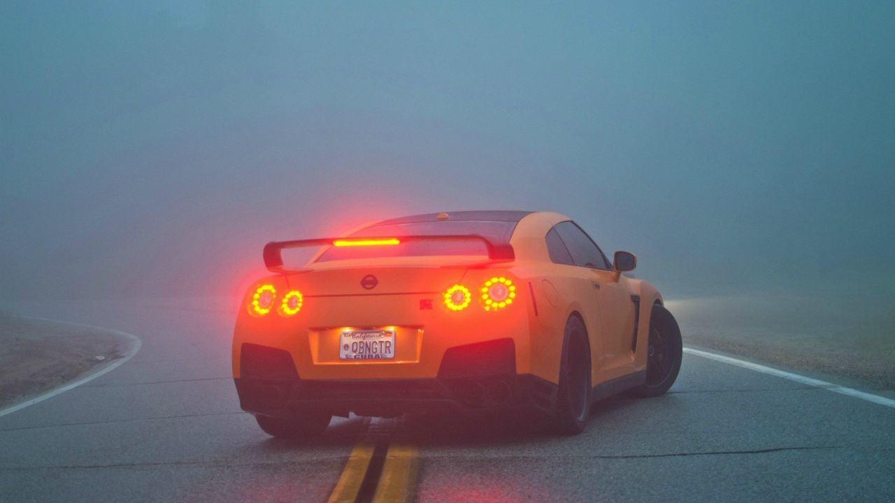 Yellow Nissan GT-R on a foggy road