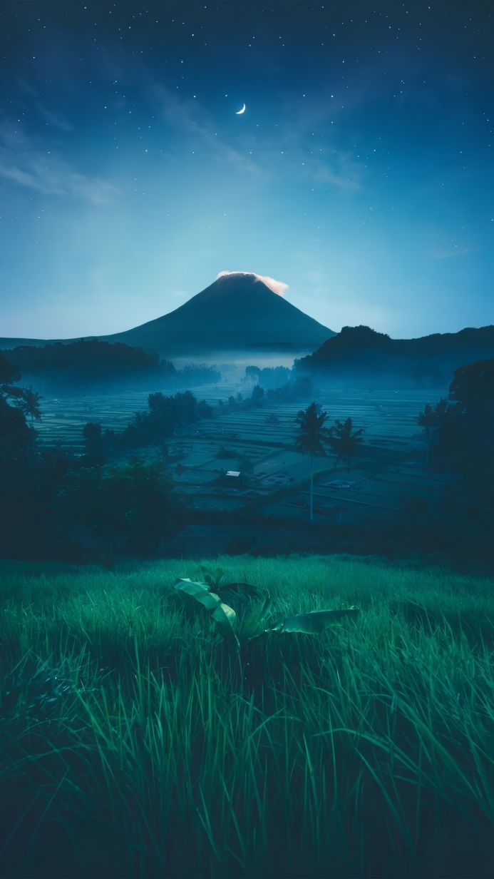 Mountain and rice terraces landscape at night under a crescent moon