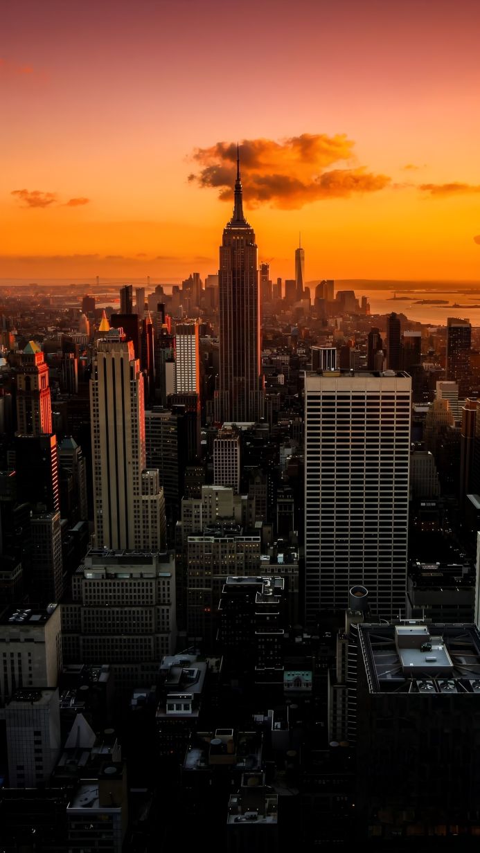 New York City skyline at sunrise, featuring the Empire State Building and One World Trade Center