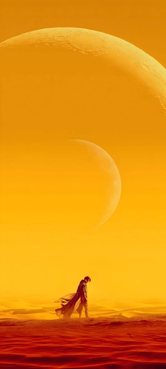 Paul Atreides walks on Arrakis in Dune, with a large moon in the background