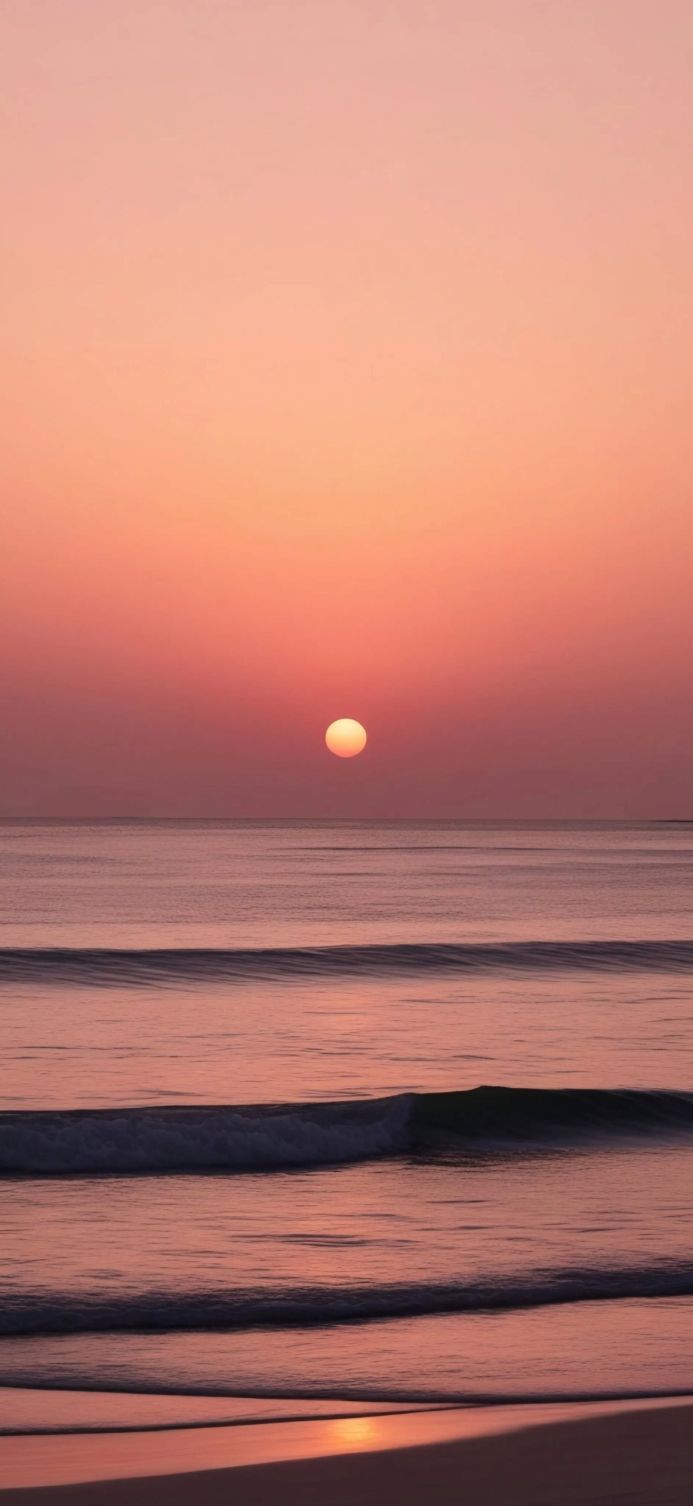 Sunrise over the ocean with waves, soft peach and pink colors