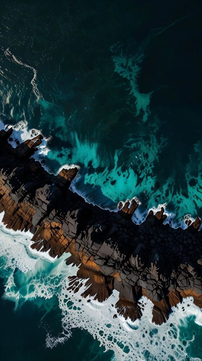 Aerial view of a rocky coastline meeting the turquoise ocean