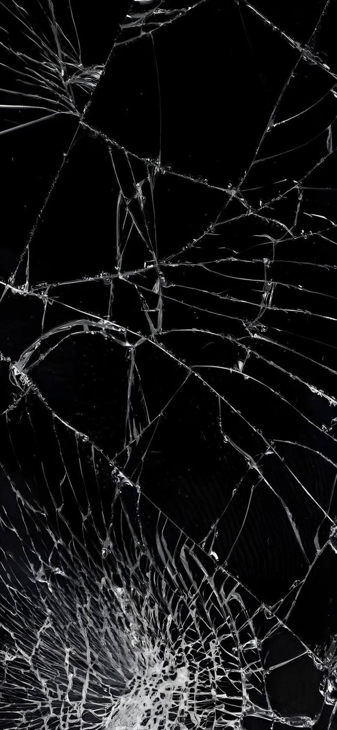 Close-up of a shattered glass surface with intricate crack patterns on a black background