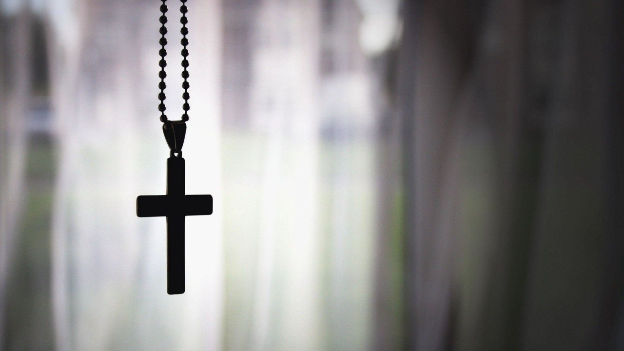 Black cross hanging from a chain