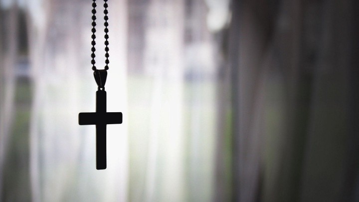Black cross hanging from a chain