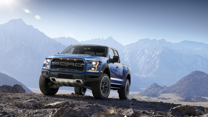 Blue Ford F-150 Raptor truck on rocky terrain