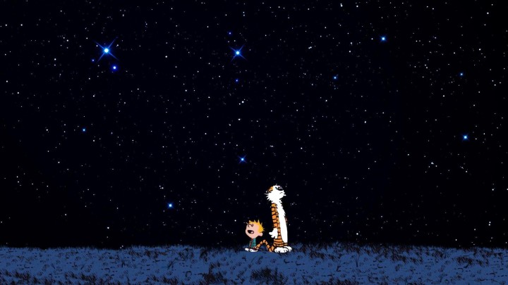 Calvin and Hobbes sitting on a bench viewed from back