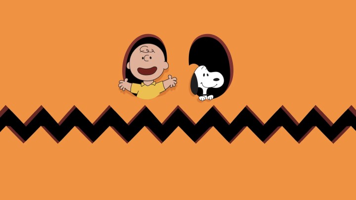 Charlie Brown and Snoopy peeking from pumpkin holes